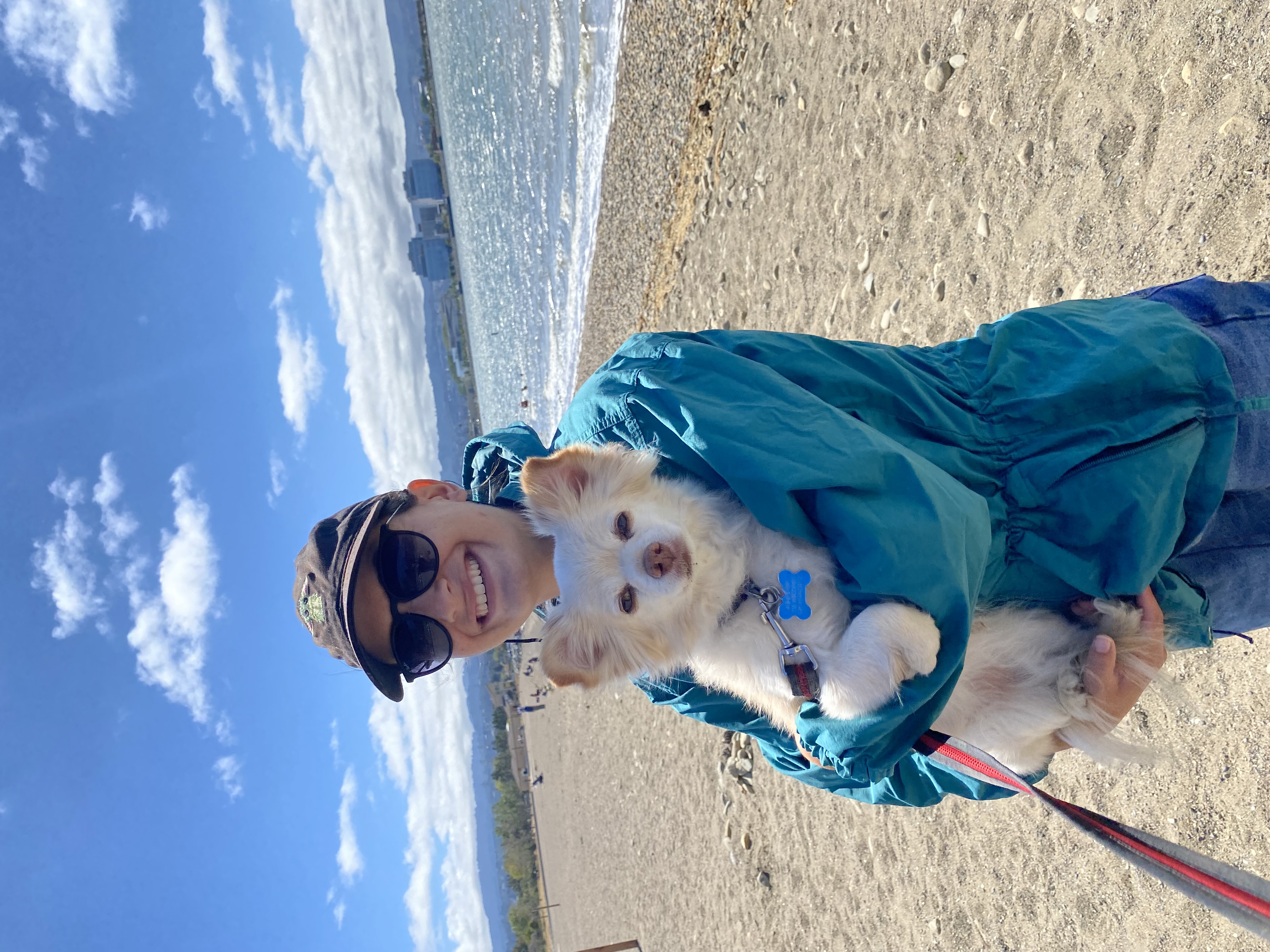Kelsey holding a small dog at the beach