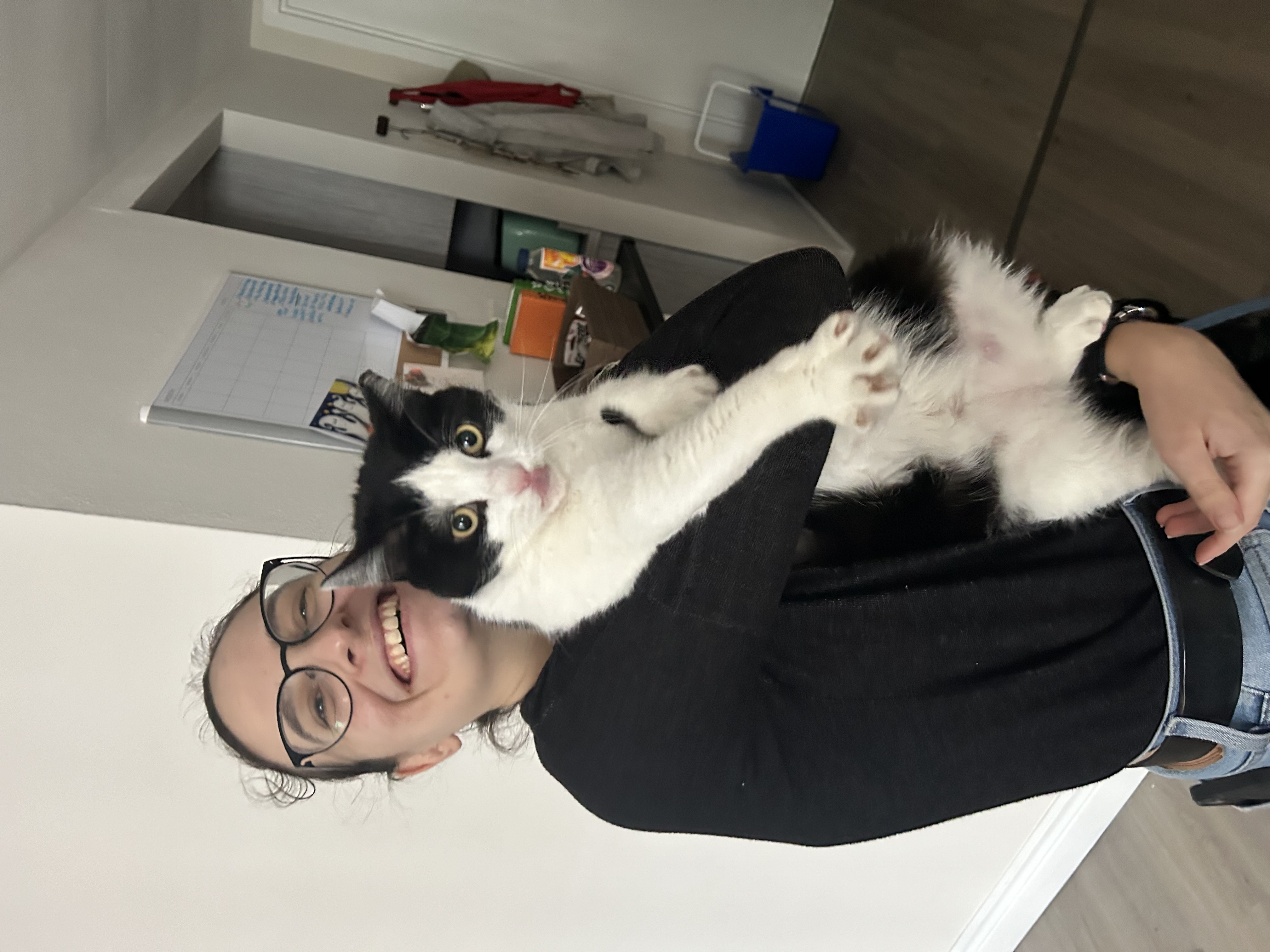Kelsey holding a black and white cat